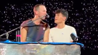 Chris Martin duetta con un fan durante il concerto a Napoli