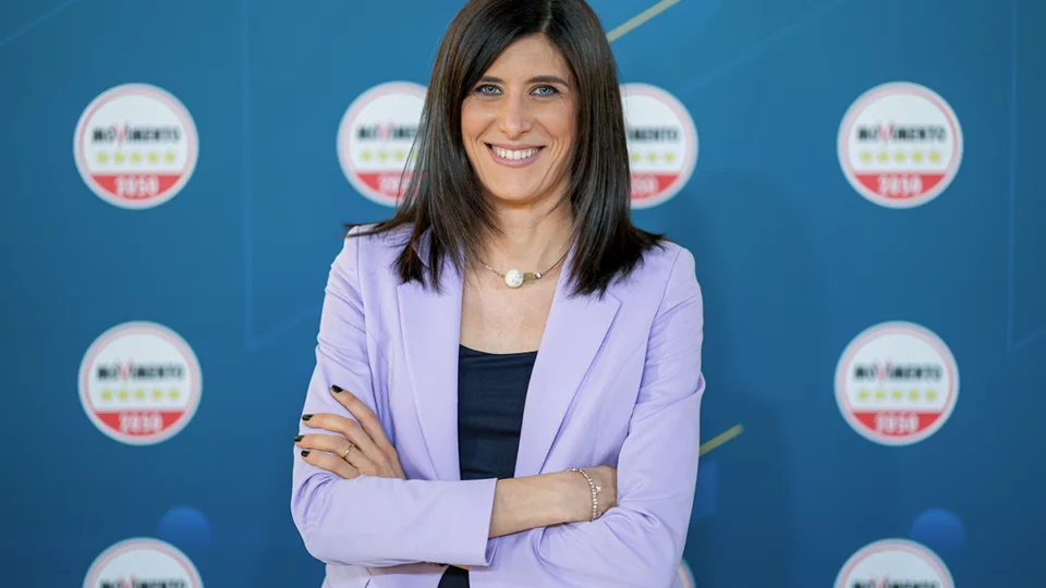 Chiara Appendino ritratta davanti al backdrop del Movimento 5 Stelle